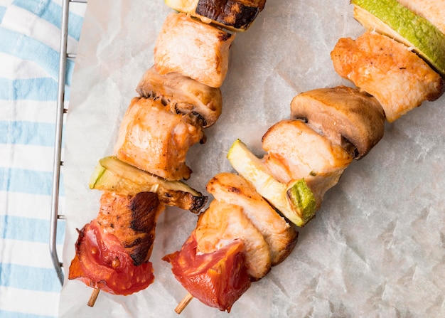 Foto gratuita brochetas de pollo vista superior en papel pergamino