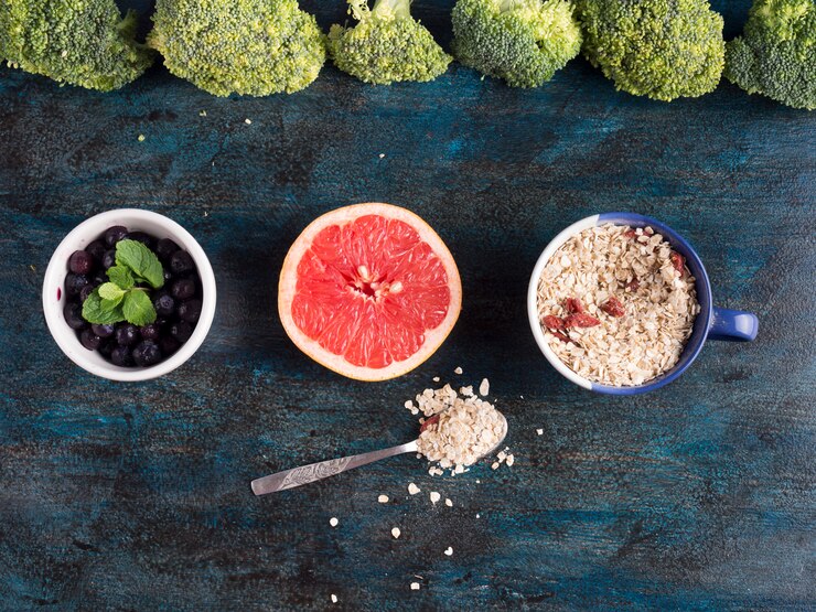 Foto gratuito brócoli con bayas y pomelo en mesa