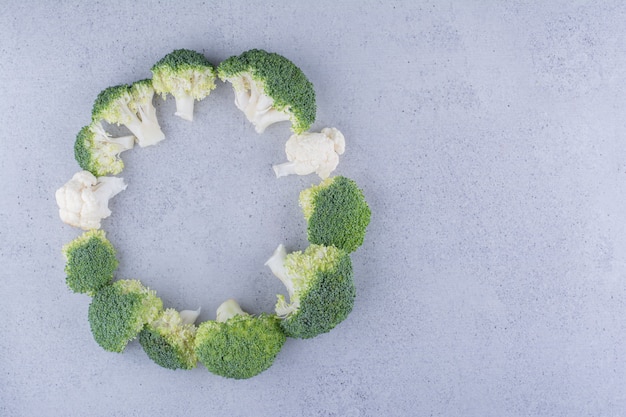 Brócoli dispuesto en un anillo sobre fondo de mármol.