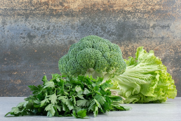 Brócoli, hojas de cilantro y lechuga sobre superficie de piedra. Foto de alta calidad