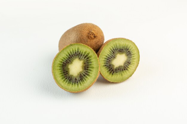 Brown amargo kiwis en rodajas aislado en la superficie blanca