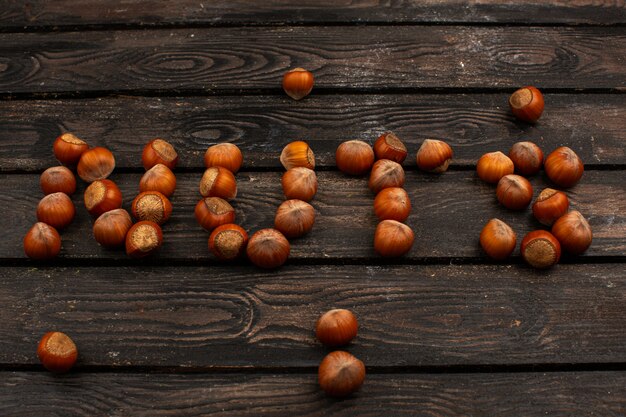 Brown nueces enteras sabrosas nueces palabra en forma de una mesa rústica de madera marrón