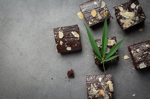 Brownies de cannabis y hojas de cannabis en suelo oscuro