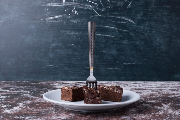 Brownies de chocolate en un plato blanco con un tenedor.