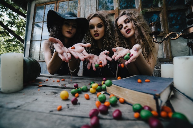 Foto gratuita brujas diabólicas lanzando caramelos