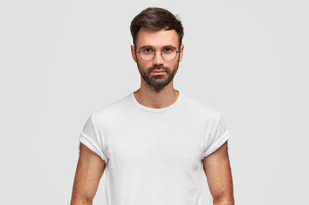 Brunet hombre vestido con anteojos redondos y camiseta blanca