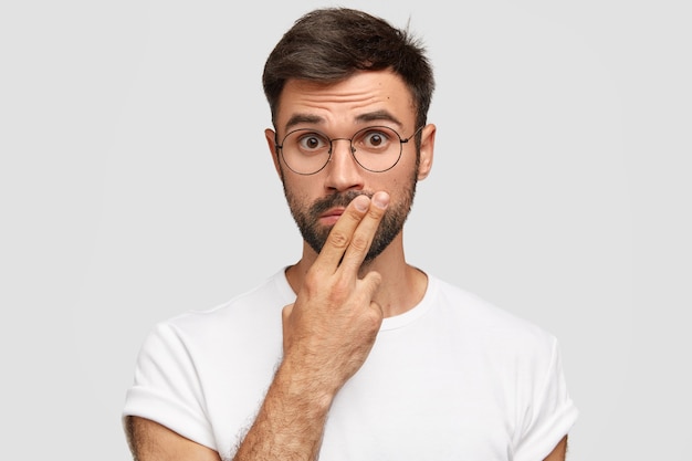 Brunet hombre vestido con anteojos redondos y camiseta blanca