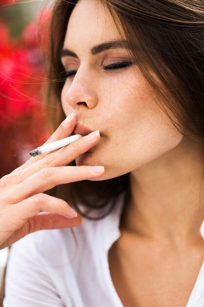 Brunette mujer fuma un cigarro