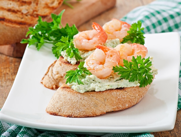 Bruschetta con una pasta de guisantes y camarones