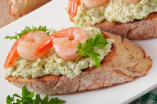 Bruschetta con una pasta de guisantes y camarones