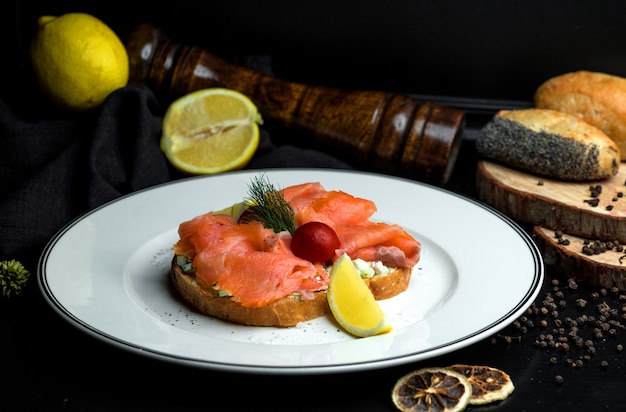 Foto gratuita bruschetta de salmón ahumado con aguacate servido con limón