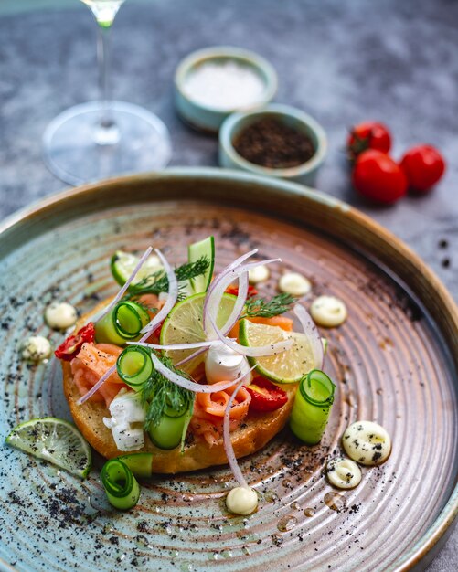 Bruschetta de salmón con mozzarella de pepino eneldo cebolla roja tomate seco y lima