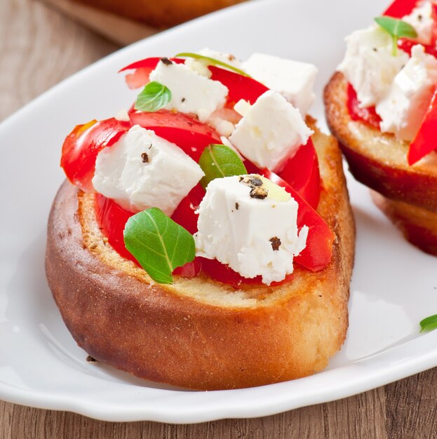 Bruschetta con tomate, queso feta y albahaca