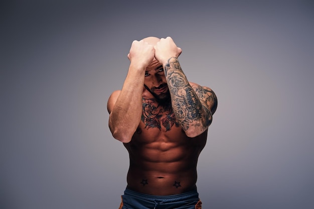 Foto gratuita brutal luchador de cabeza rapada y cuerpo tatuado.