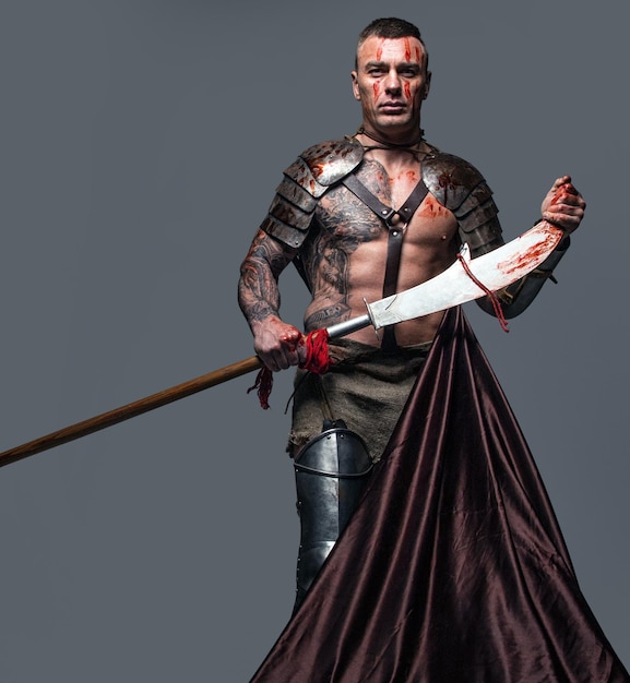 Brutal y peligroso luchador medievel tatuado con máscara de calavera en armadura