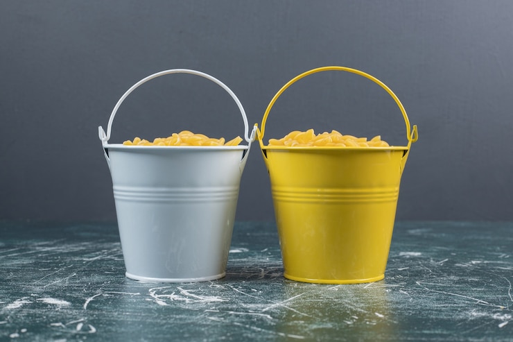 Photo Gratis buckets of raw spiral pasta on blue background. high quality photo