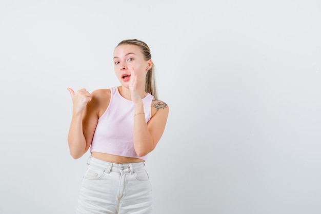 Buena chica está mostrando sus dedos sobre fondo blanco.