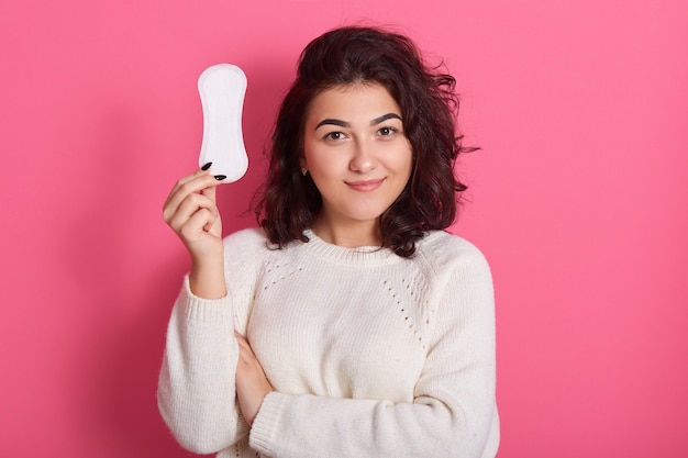 Buena chica femenina sostiene una toalla sanitaria limpia