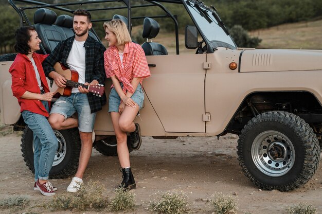 Buenos amigos tocando la guitarra mientras viajan en coche