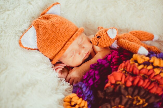 Bufanda colorida sobres bebé pequeño en sombrero de zorro