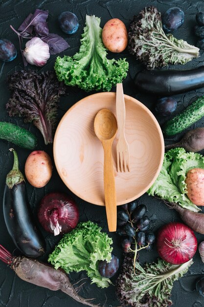 búho con cuchara y tenedor entre verduras