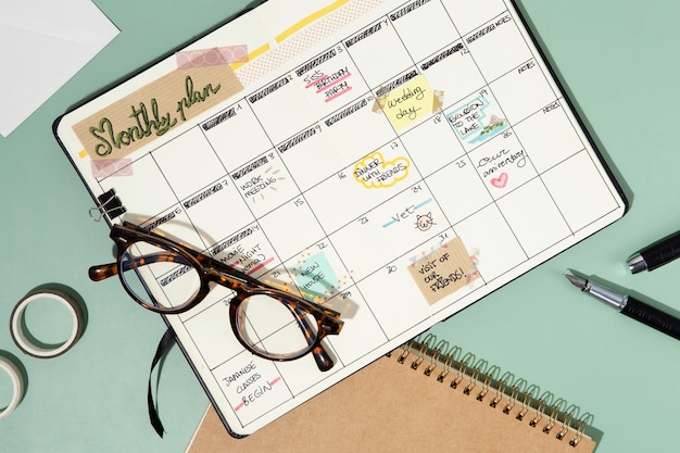 Foto gratuita bullet journal y gafas vista superior