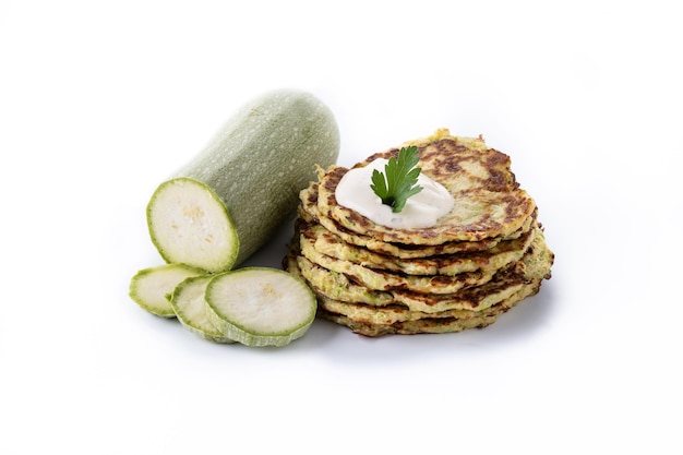 Buñuelos de calabacín con salsa de yogur aislado sobre fondo blanco.