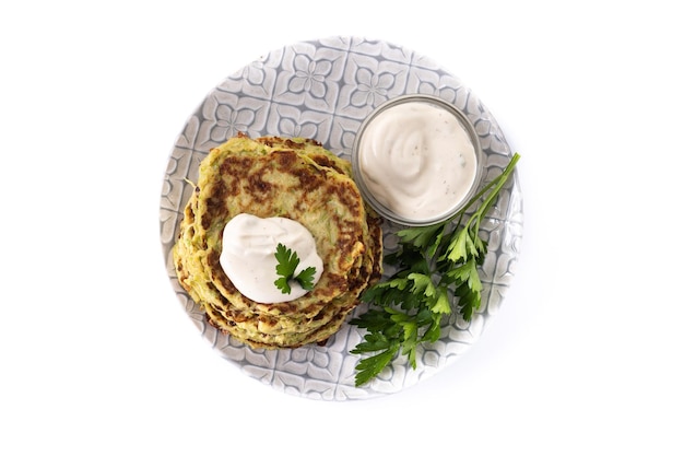 Buñuelos de calabacín con salsa de yogur aislado sobre fondo blanco.