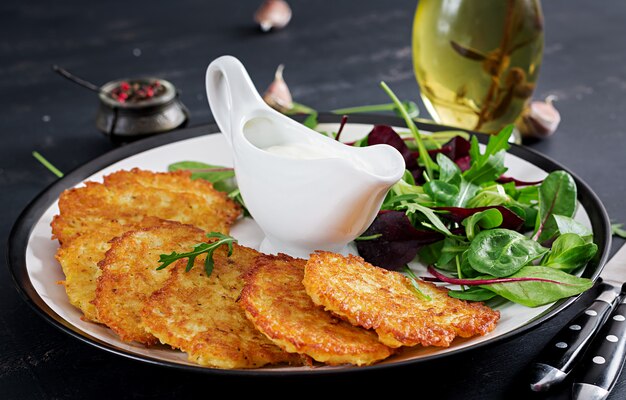 Buñuelos de papa servidos con crema agria