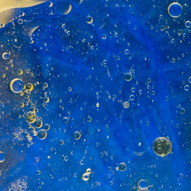 Burbujas de aceite flotando sobre fondo azul acuarela
