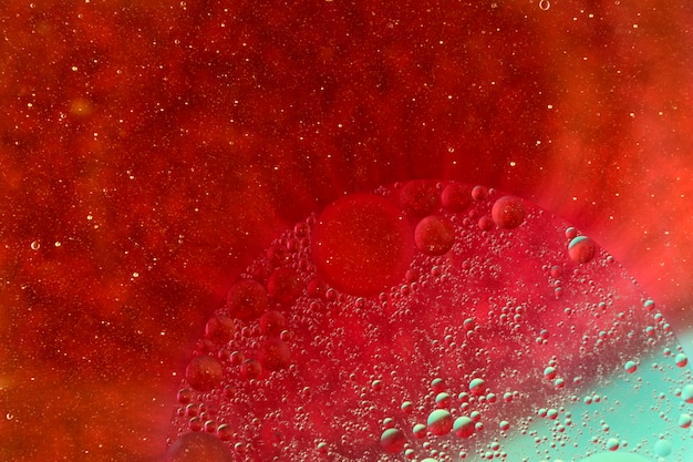 Burbujas de aceite flotando sobre fondo rojo vibrante