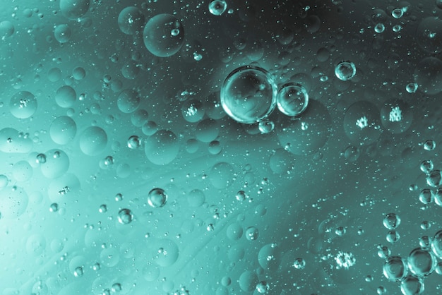 Burbujas aceitosas en agua con gotas.