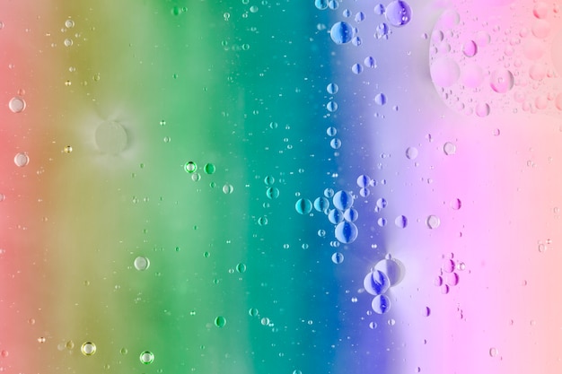 Foto gratuita burbujas de agua sobre el fondo del arco iris