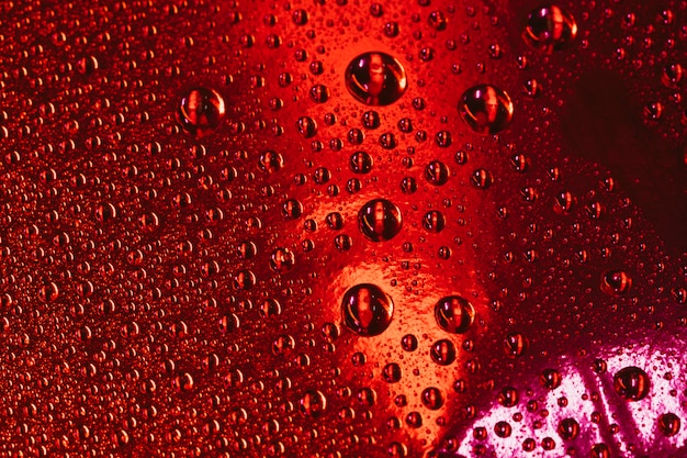 Burbujas de agua sobre el fondo rojo con textura