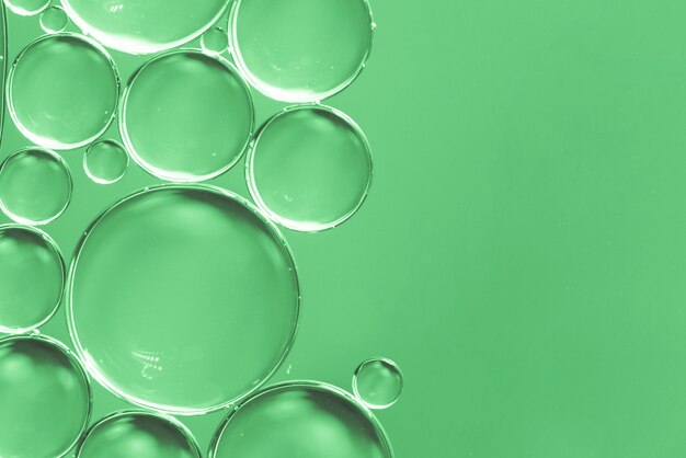 Burbujas de aire abstractas en líquido sobre fondo verde