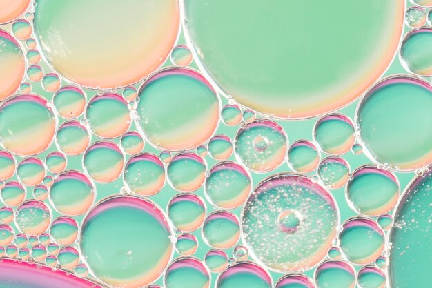 Burbujas de aire transparentes en agua en el fondo borroso colorido liso