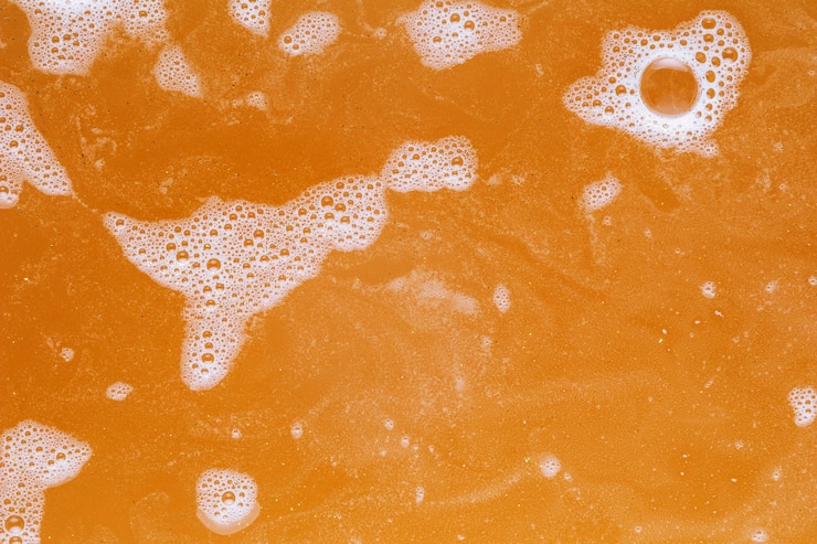 Foto gratuito burbujas blancas sobre agua naranja