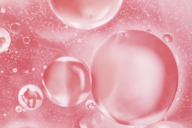 Burbujas rosas asimétricas en aceite abstracto.
