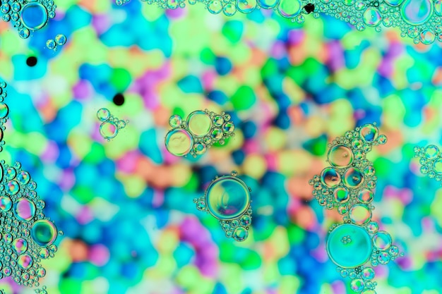 Burbujas transparentes sobre superficie de color perla fría.