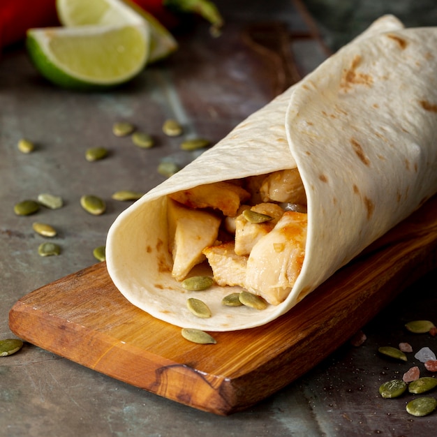 Burrito en tabla de cortar cerca de semillas de cardamomo