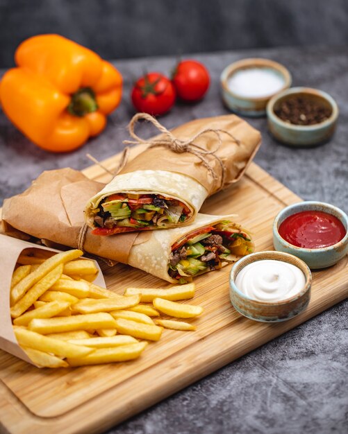 Burrito de ternera con lechuga tomate pepino jalapeño servido con papas fritas y salsas verticales