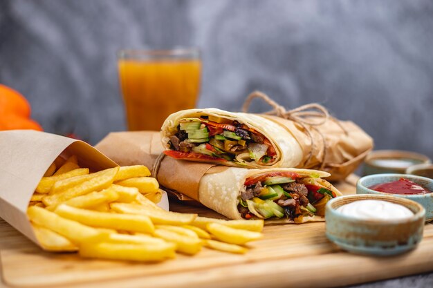 Burrito de ternera con lechuga tomate pepino jalapeño servido con papas fritas y salsas