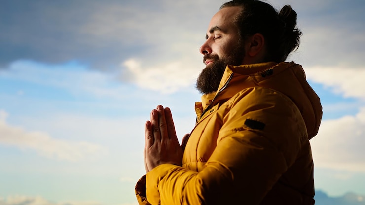 Foto gratuito buscador de aventuras haciendo una postura de meditación en la cima de la montaña