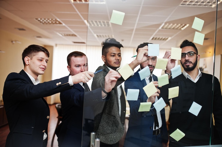 Photo Gratis business mans pointing on glass with colorful paper notes diverse group of male employees in formal wear using stickers