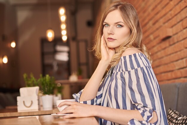 Cabello de mujer rubia con taza de café