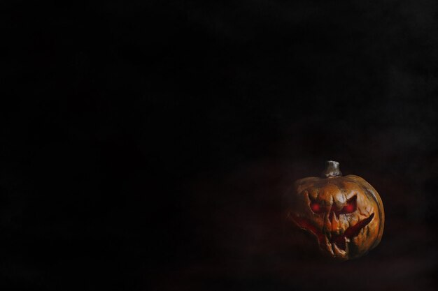 Cabeza de calabaza de Halloween con ojos rojos fondo negro