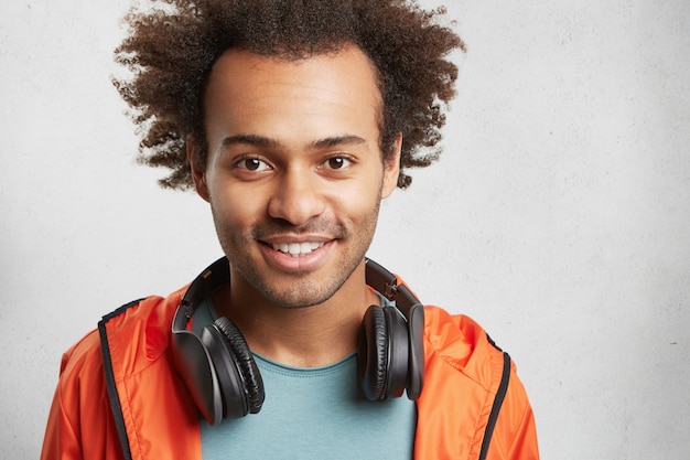 En la cabeza de un hombre guapo de raza mixta con pelo tupido, tiene buen humor