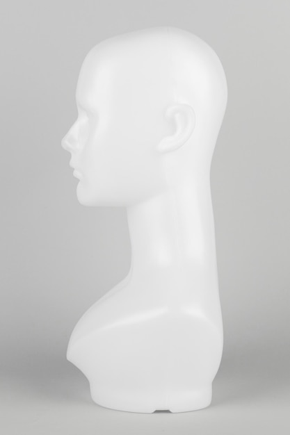 Foto gratuita cabeza de maniquí blanco de perfil sobre un fondo gris