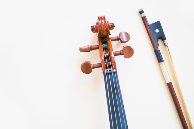 Cabeza del violín clásico con arco sobre fondo blanco