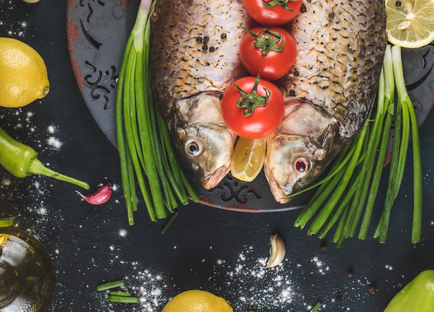 Foto gratuita cabezas de pescado crudo en la bandeja decorativa con verduras